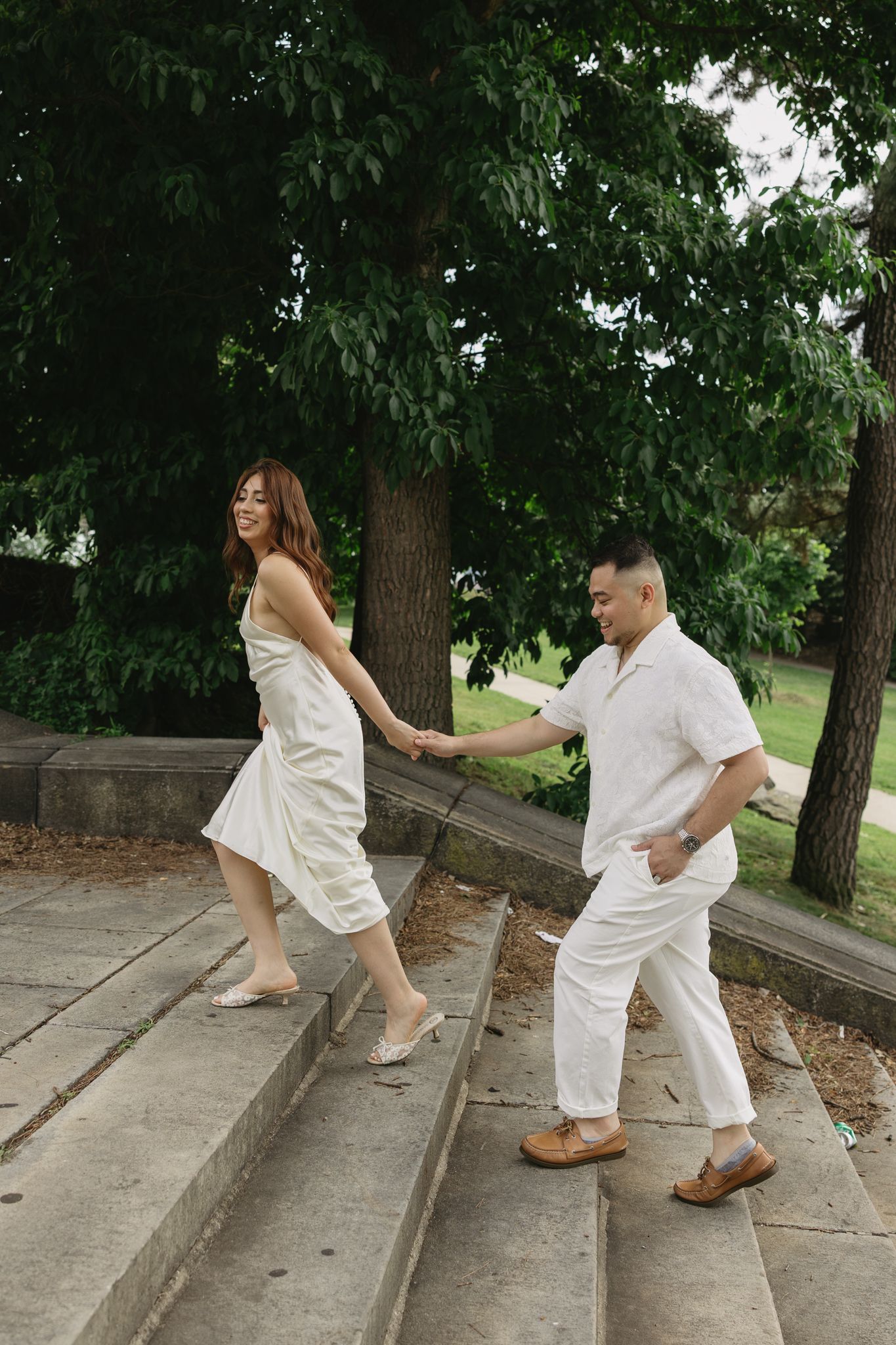 Elegant couple embracing during their engagement session at Fairmount Water Works in Philadelphia with the Schuylkill River and historic arc