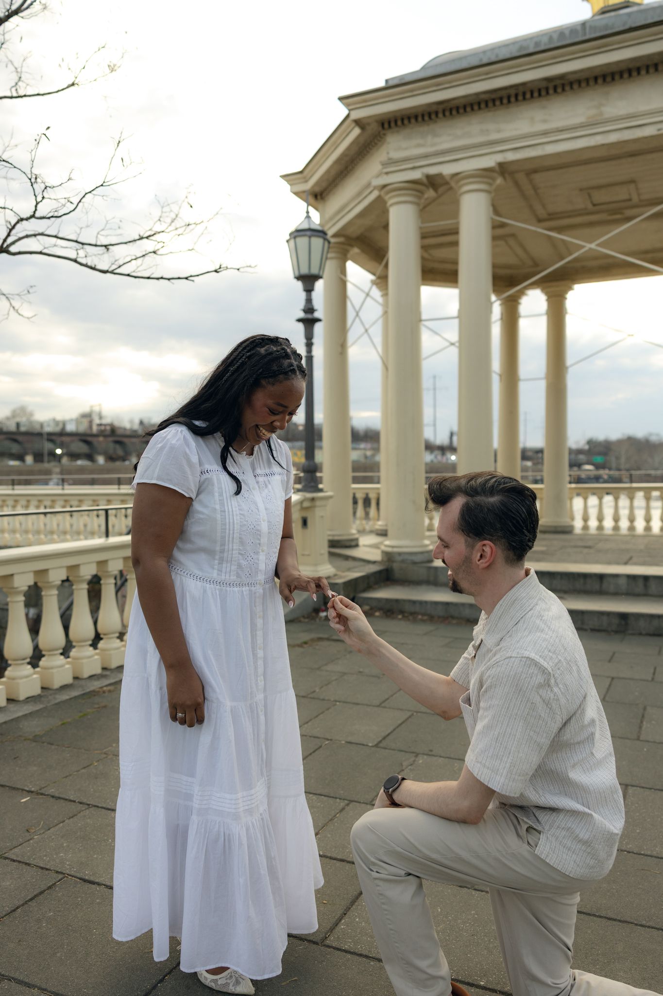 Engaged couple posing at Fairmount Water Works in Philadelphia with scenic river views and historic architecture, capturing romantic engagem