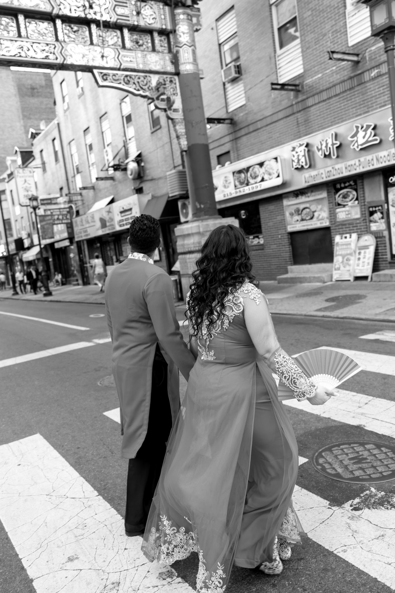 Couple laughing together during an engagement session in Philadelphia Chinatown with city lights and historic architecture-6.jpg