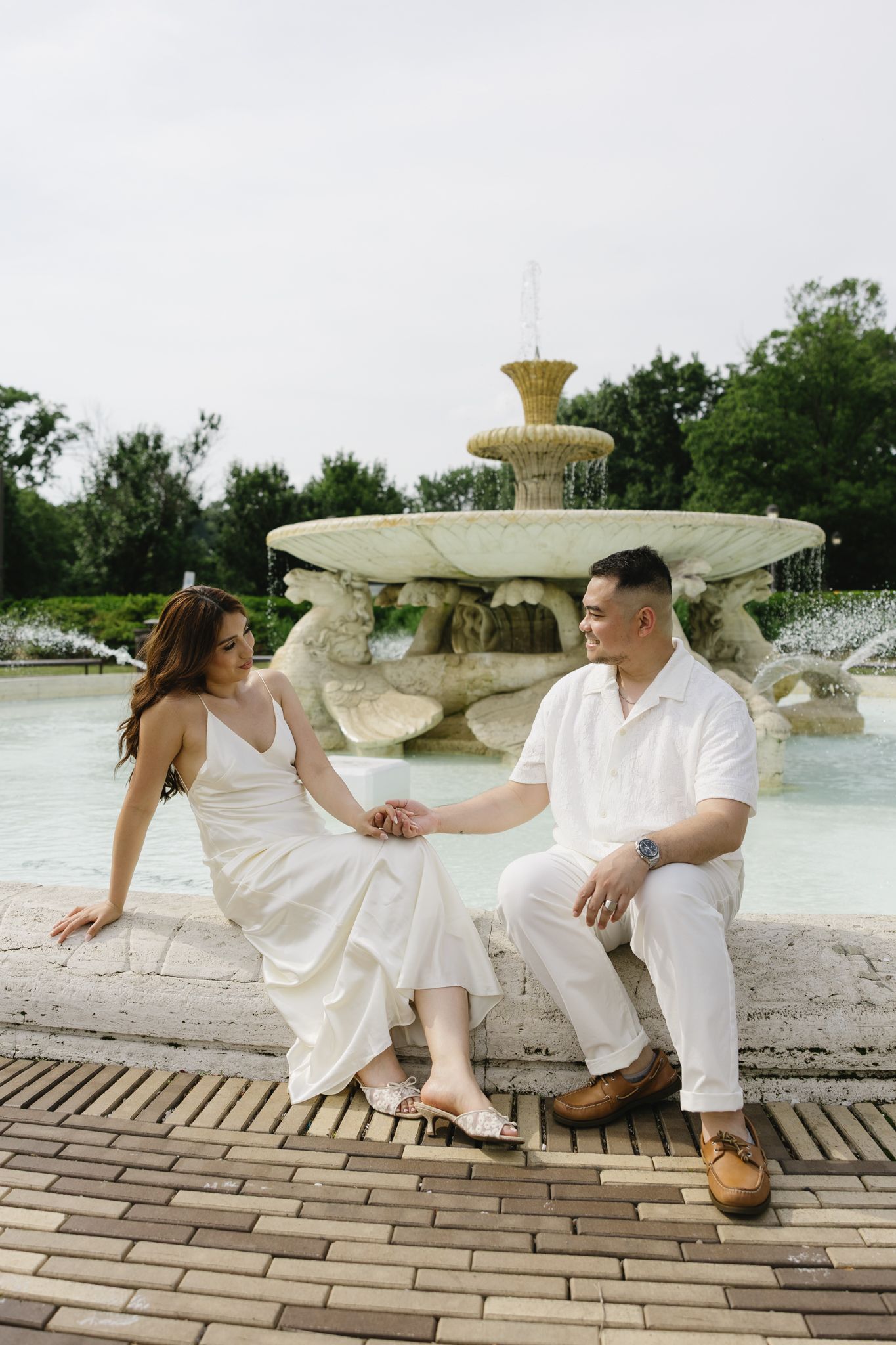 Elegant couple embracing during their engagement session at Fairmount Water Works in Philadelphia with the Schuylkill River and historic arc