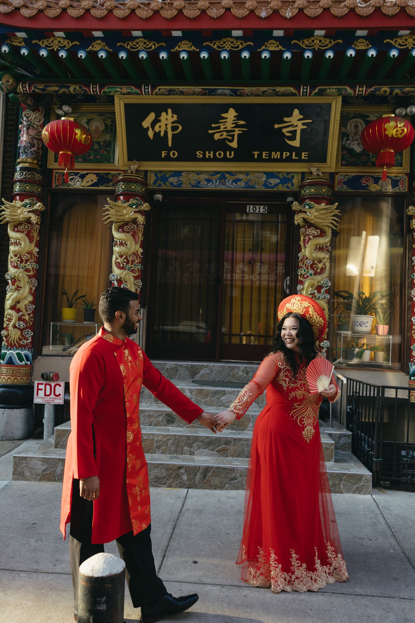 Couple laughing together during an engagement session in Philadelphia Chinatown with city lights and historic architecture-6.jpg