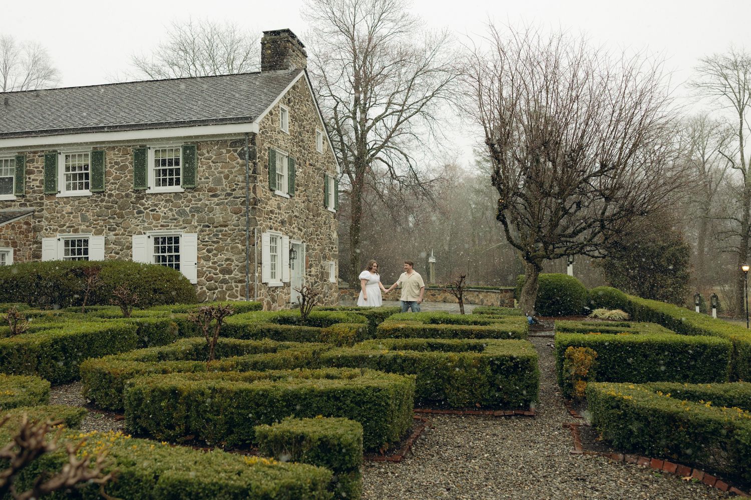 Romantic engagement photos at Appleford Estate near Philadelphia featuring a couple walking through lush gardens and historic architecture