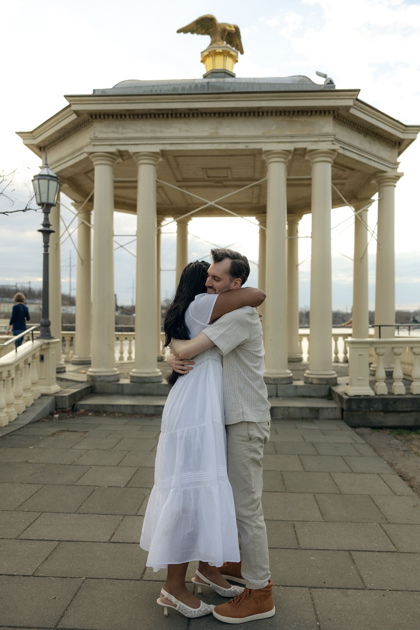 Engaged couple posing at Fairmount Water Works in Philadelphia with scenic river views and historic architecture, capturing romantic engagem