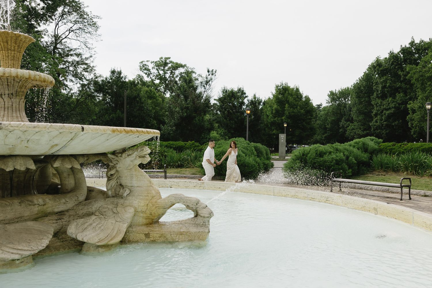 Elegant couple embracing during their engagement session at Fairmount Water Works in Philadelphia with the Schuylkill River and historic arc