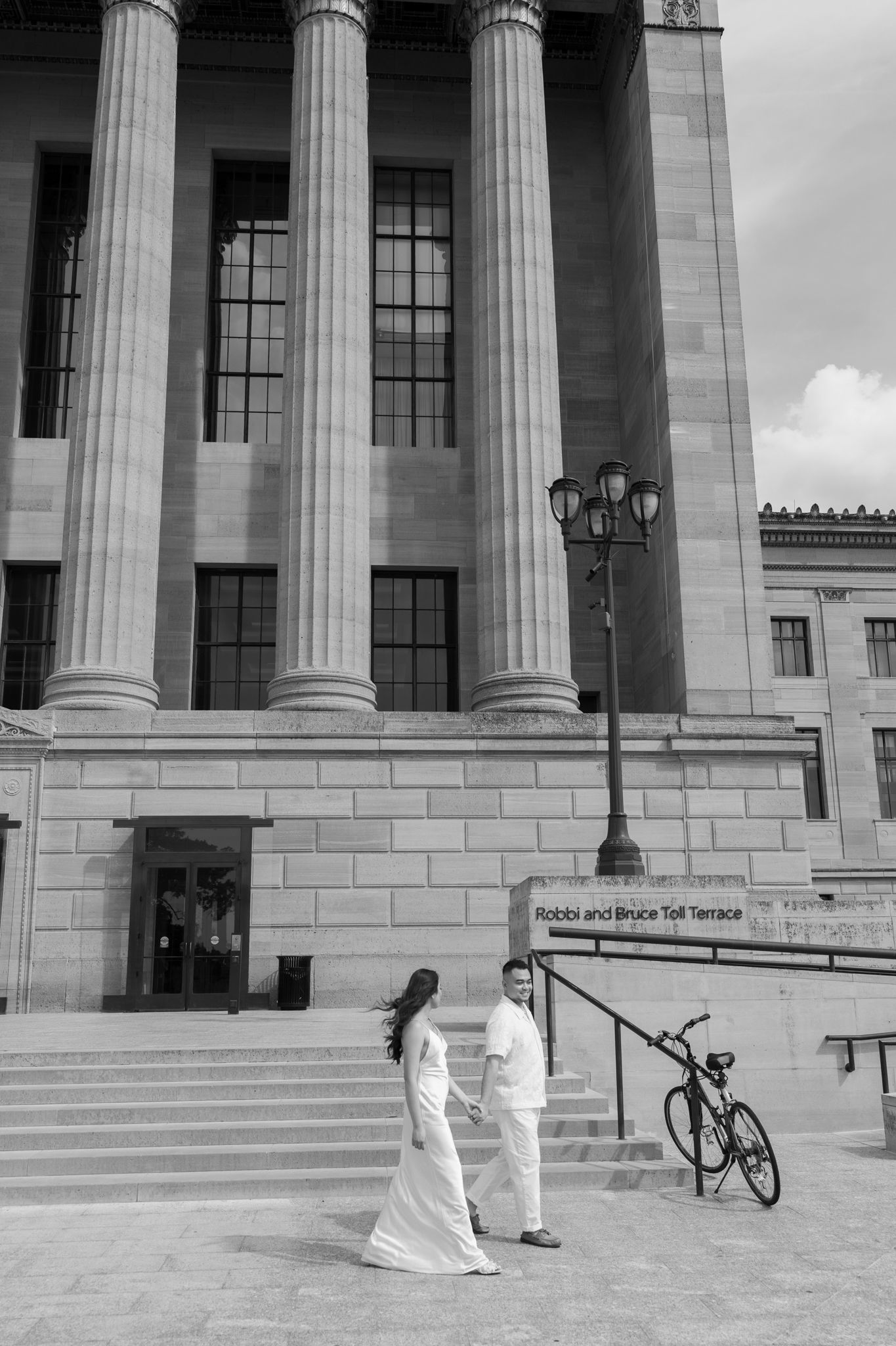 Elegant couple embracing during their engagement session at Fairmount Water Works in Philadelphia with the Schuylkill River and historic arc
