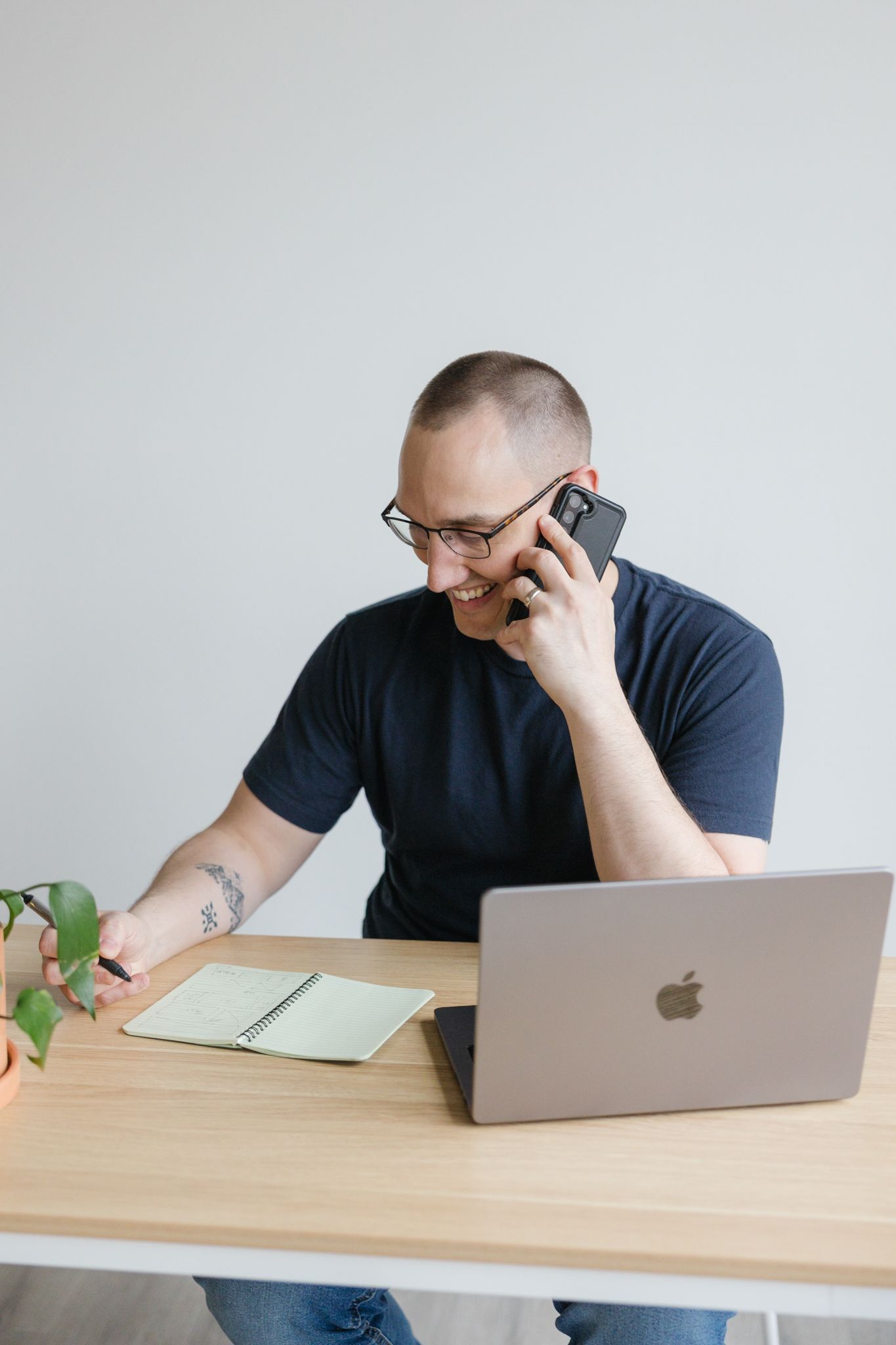 Brand photography in Philadelphia with a small business owner working on a laptop, styled desk details, and candid moments