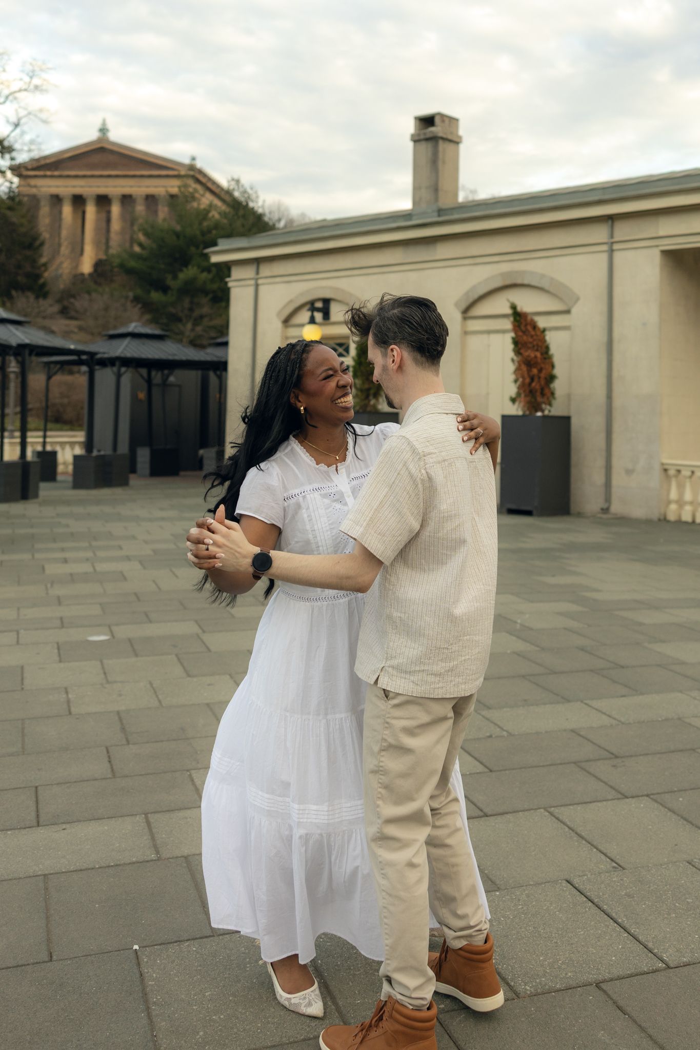 Engaged couple posing at Fairmount Water Works in Philadelphia with scenic river views and historic architecture, capturing romantic moments