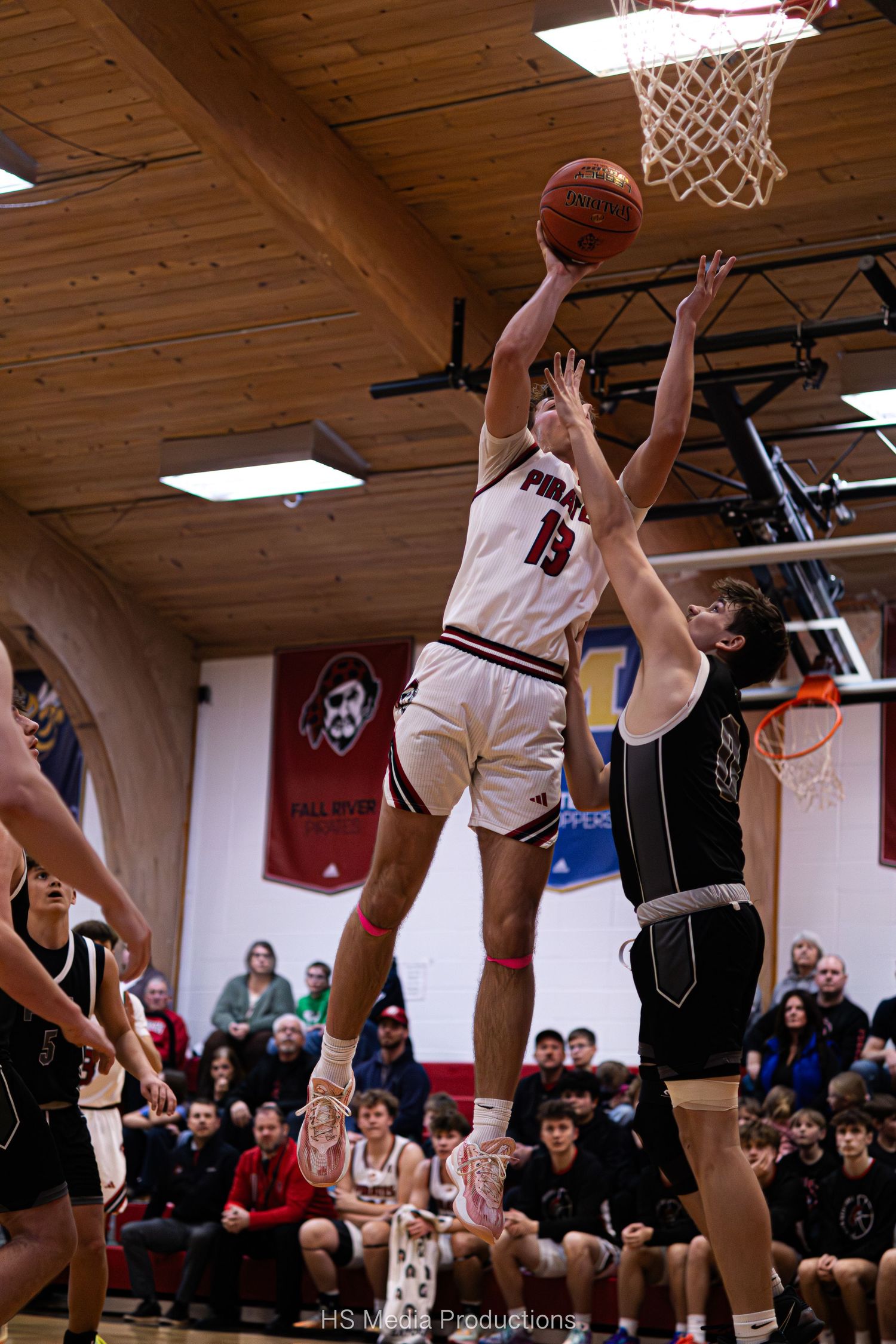 Basketball players leap high for the ball during an intense indoor game sequence showing multiple action shots.