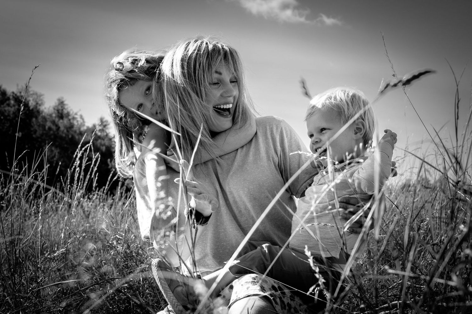 mother and children sitting in a meadow