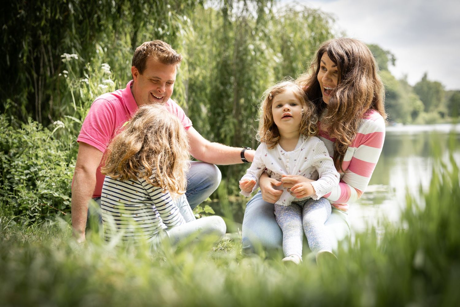 family sitting together in the grass in a garden