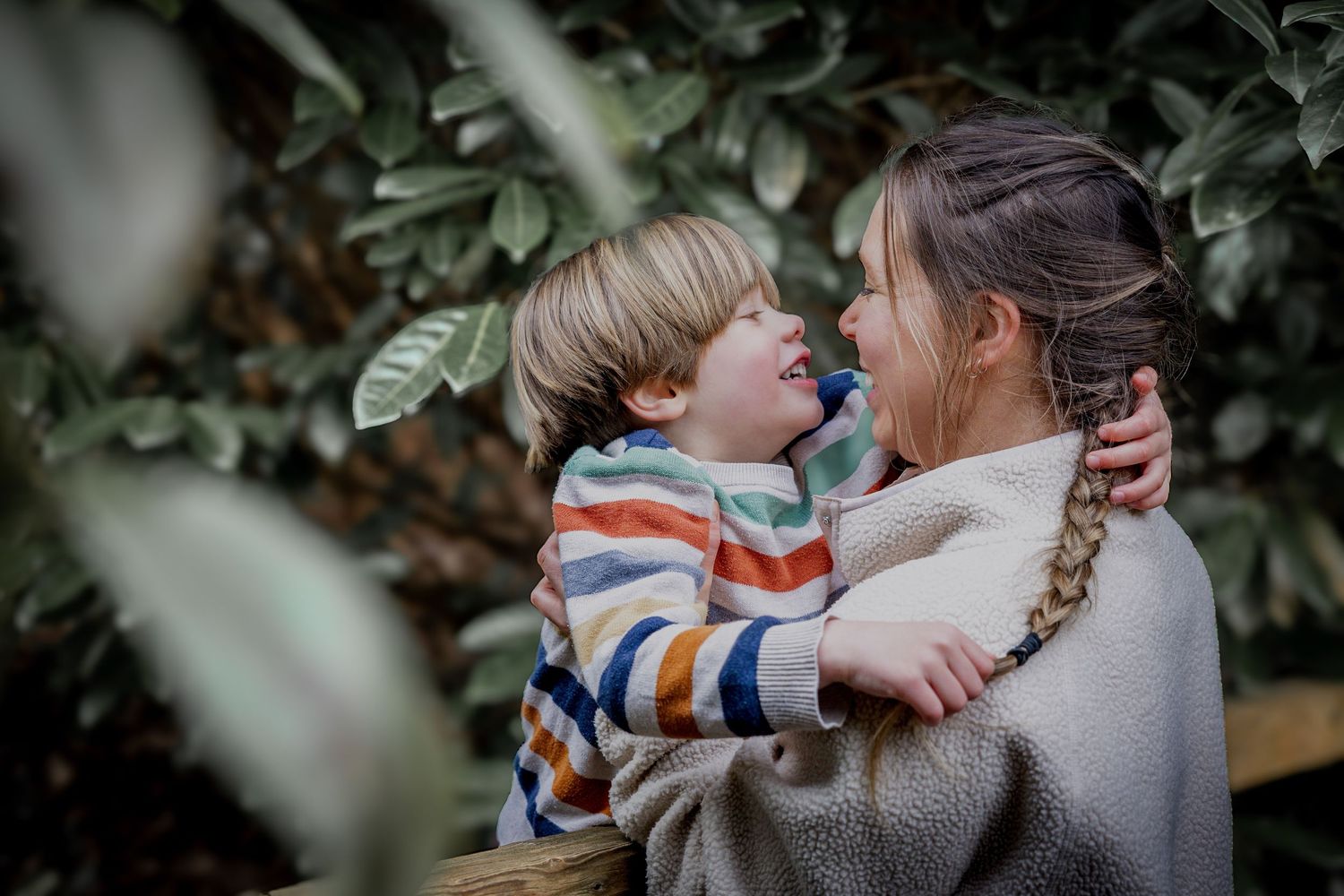 Mother holding her son on a fence.