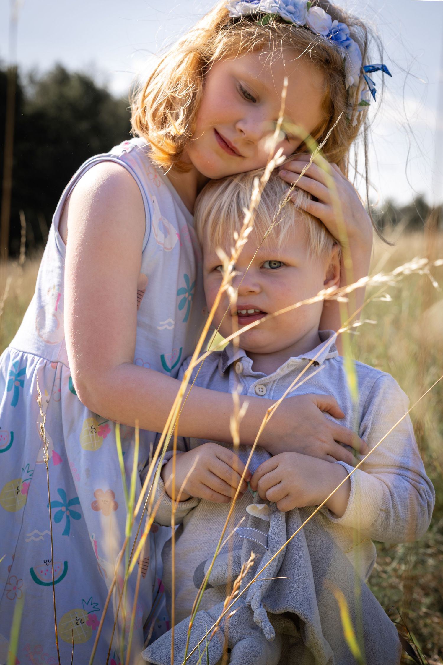 Children hugging in a grassy meadow