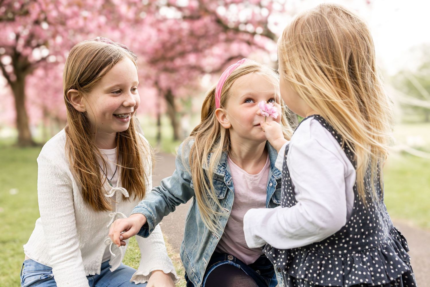 children smelling blossom in a park