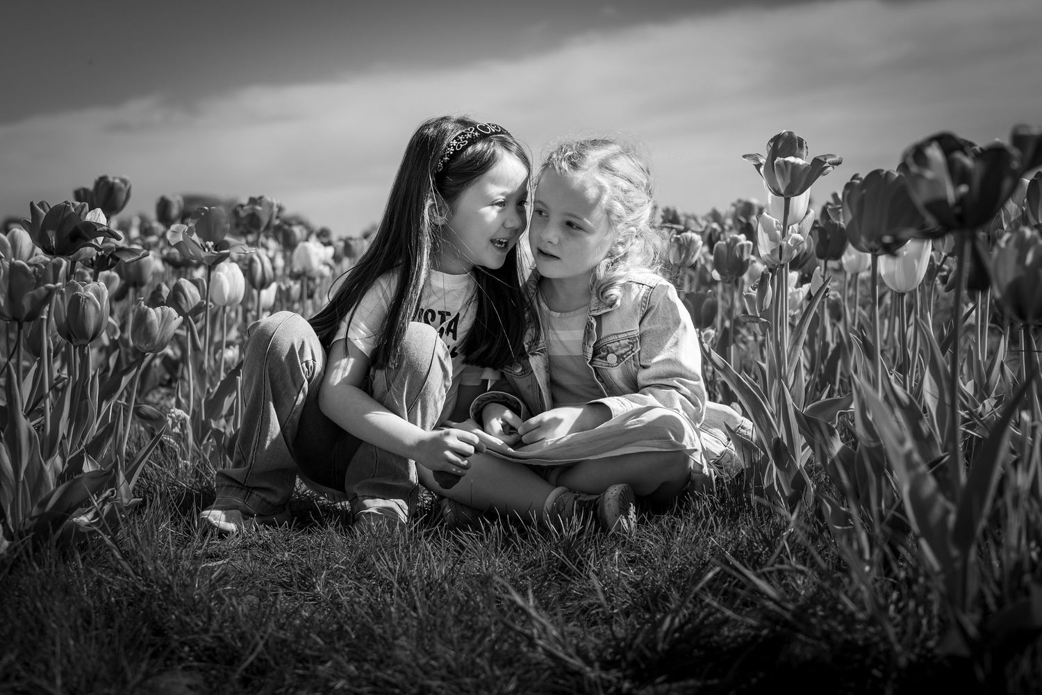 children whispering in a tulip field