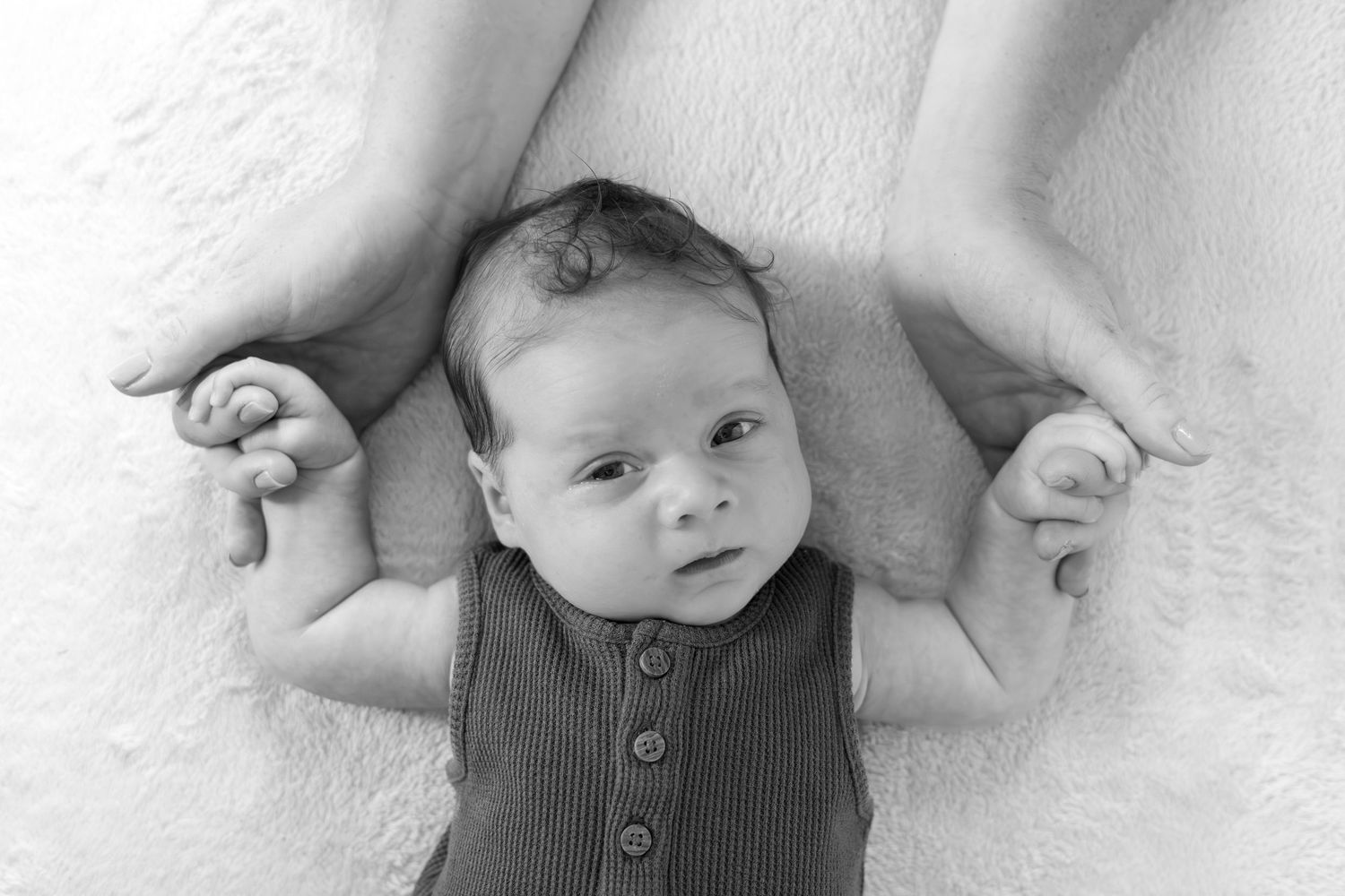 close up of baby holding mother's hands