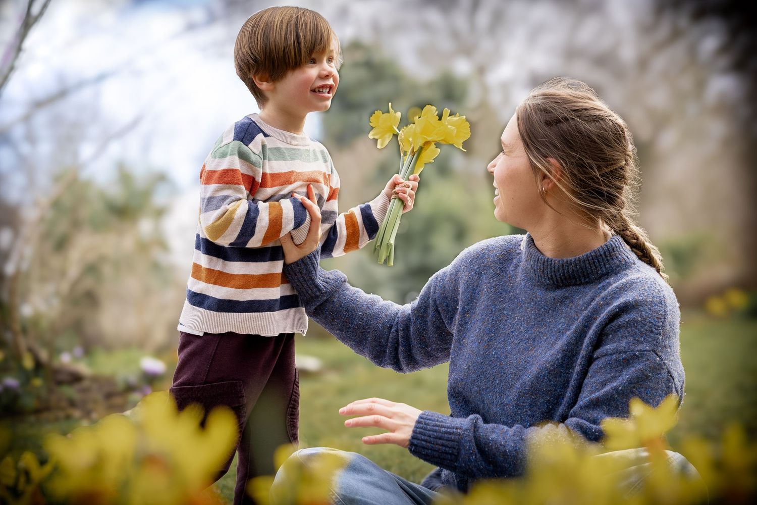 boy giving mother daffodils