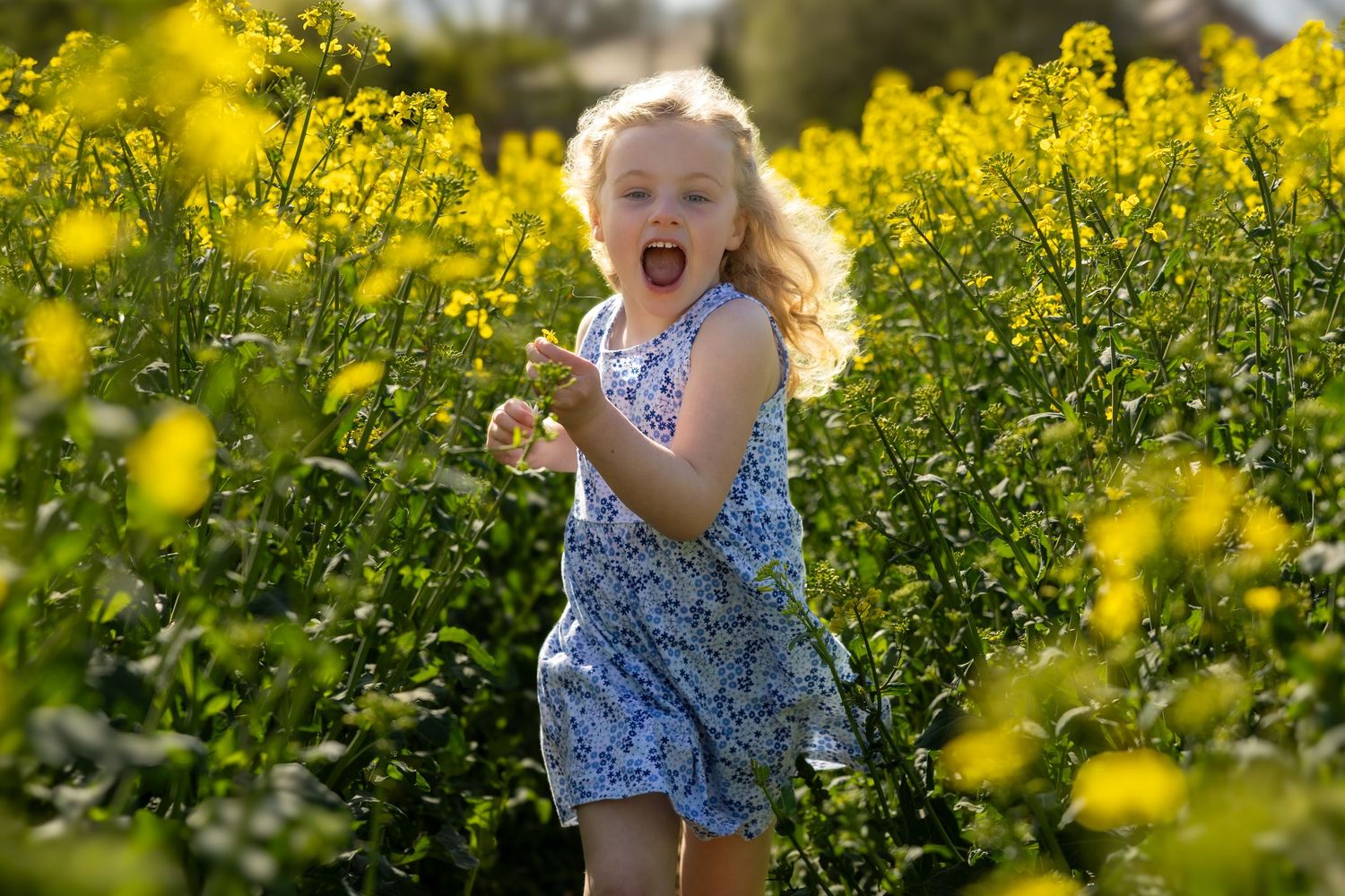 girl running in a field of yellow flowers
