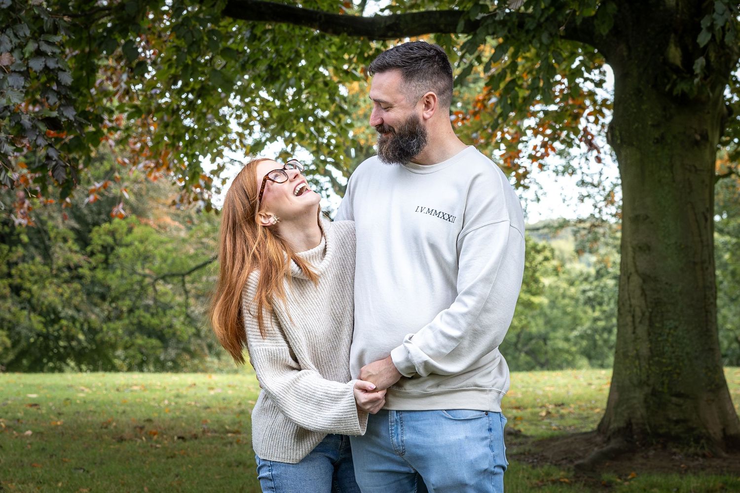 a man and a woman holding hands laughing