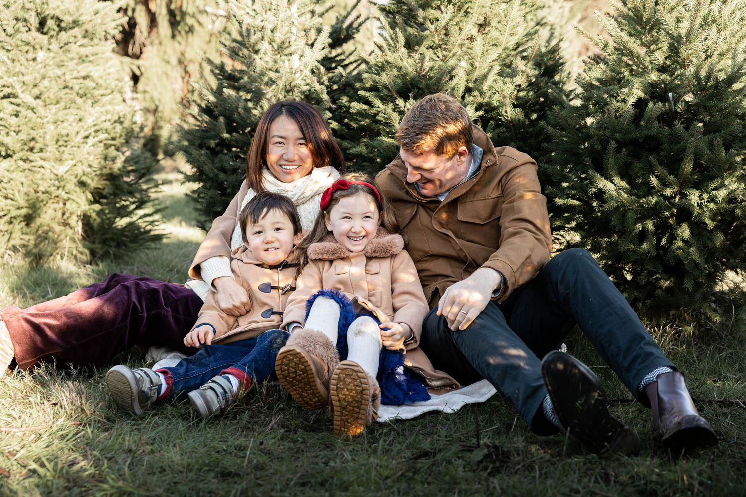 Family sitting in a Christmas tree farm