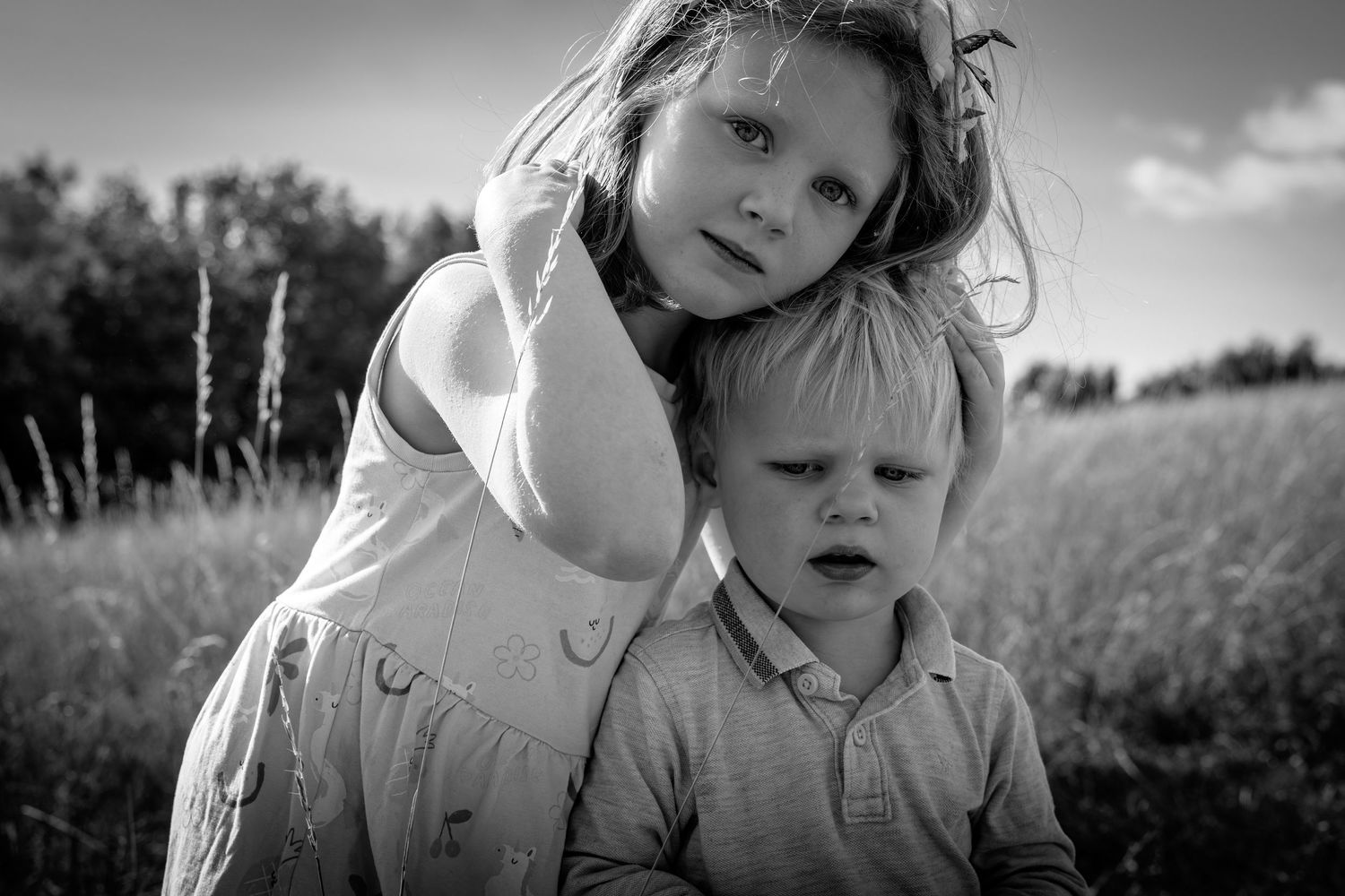 Two children standing in a grassy meadow
