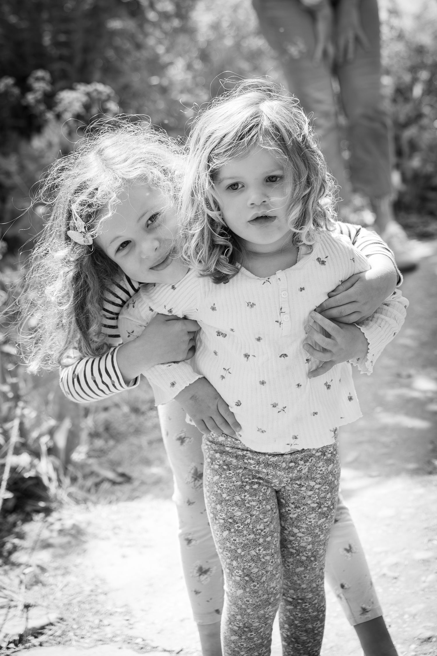 two children standing hugging on a path