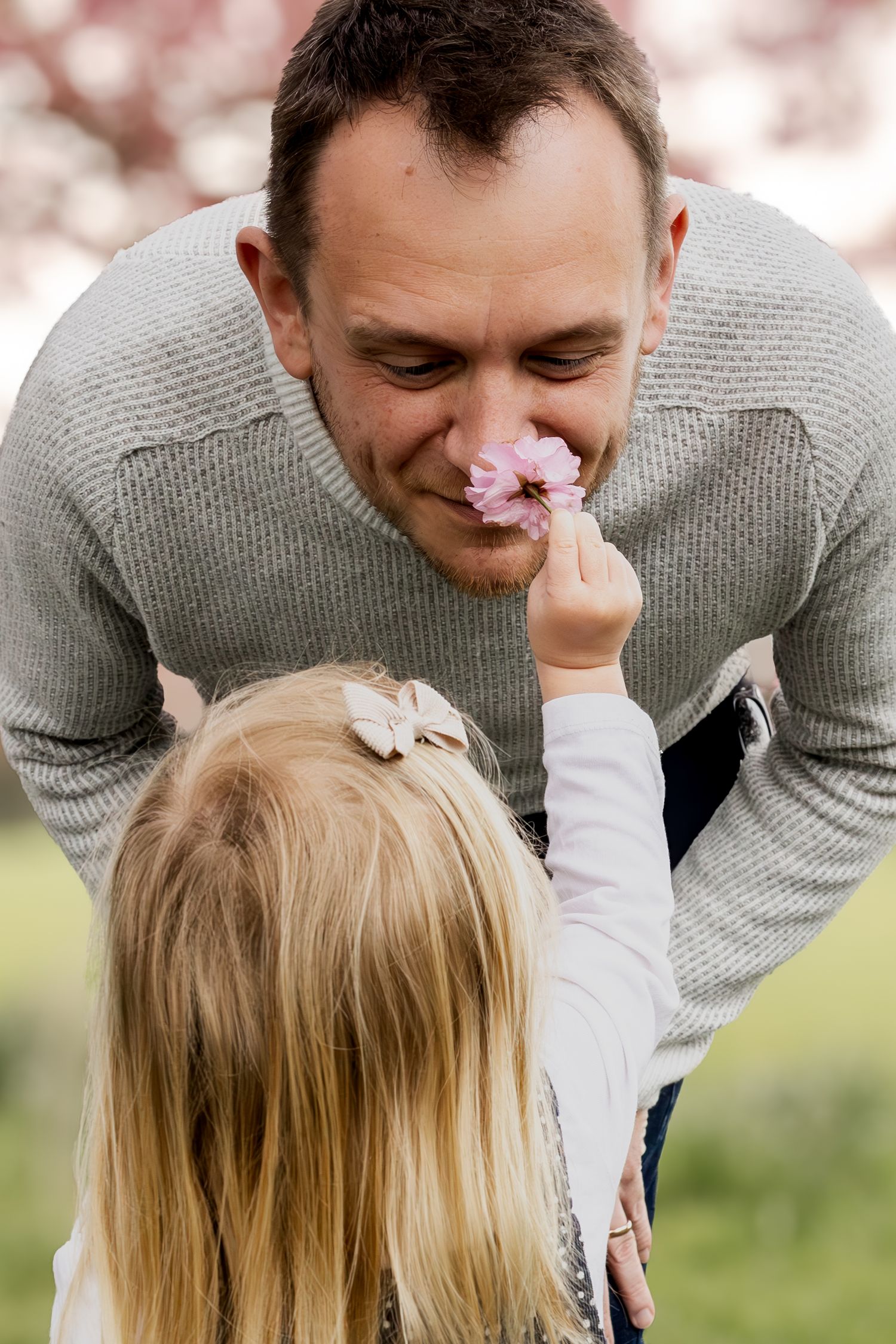 child holding a flower for father to smell