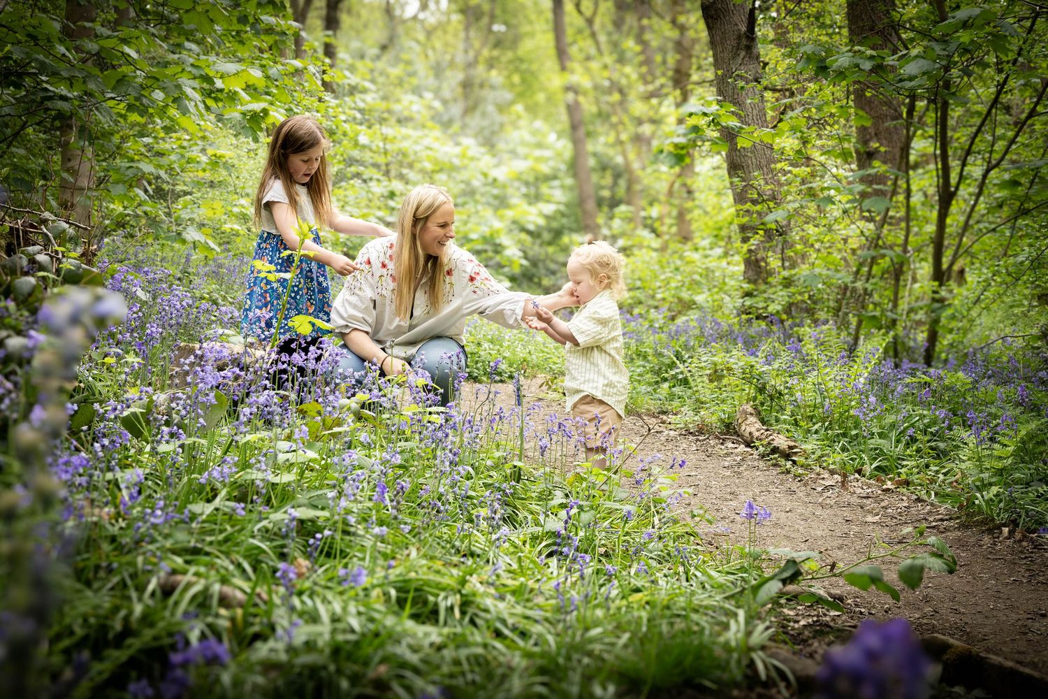 family playing in a bluebell wood
