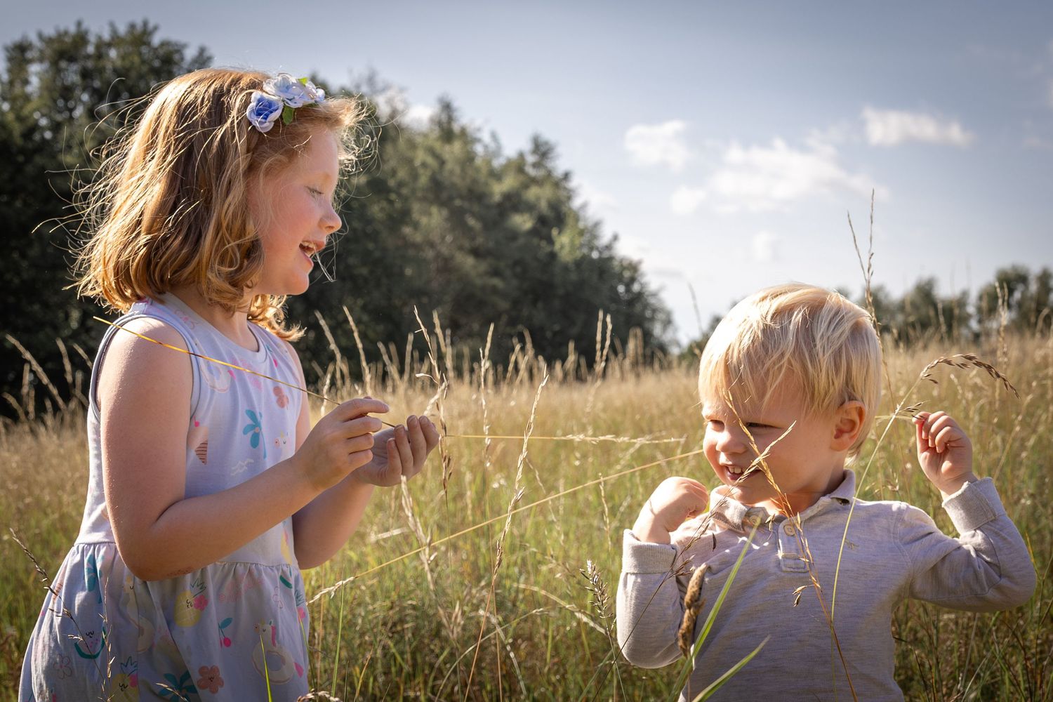 children playing with grass in a meadow