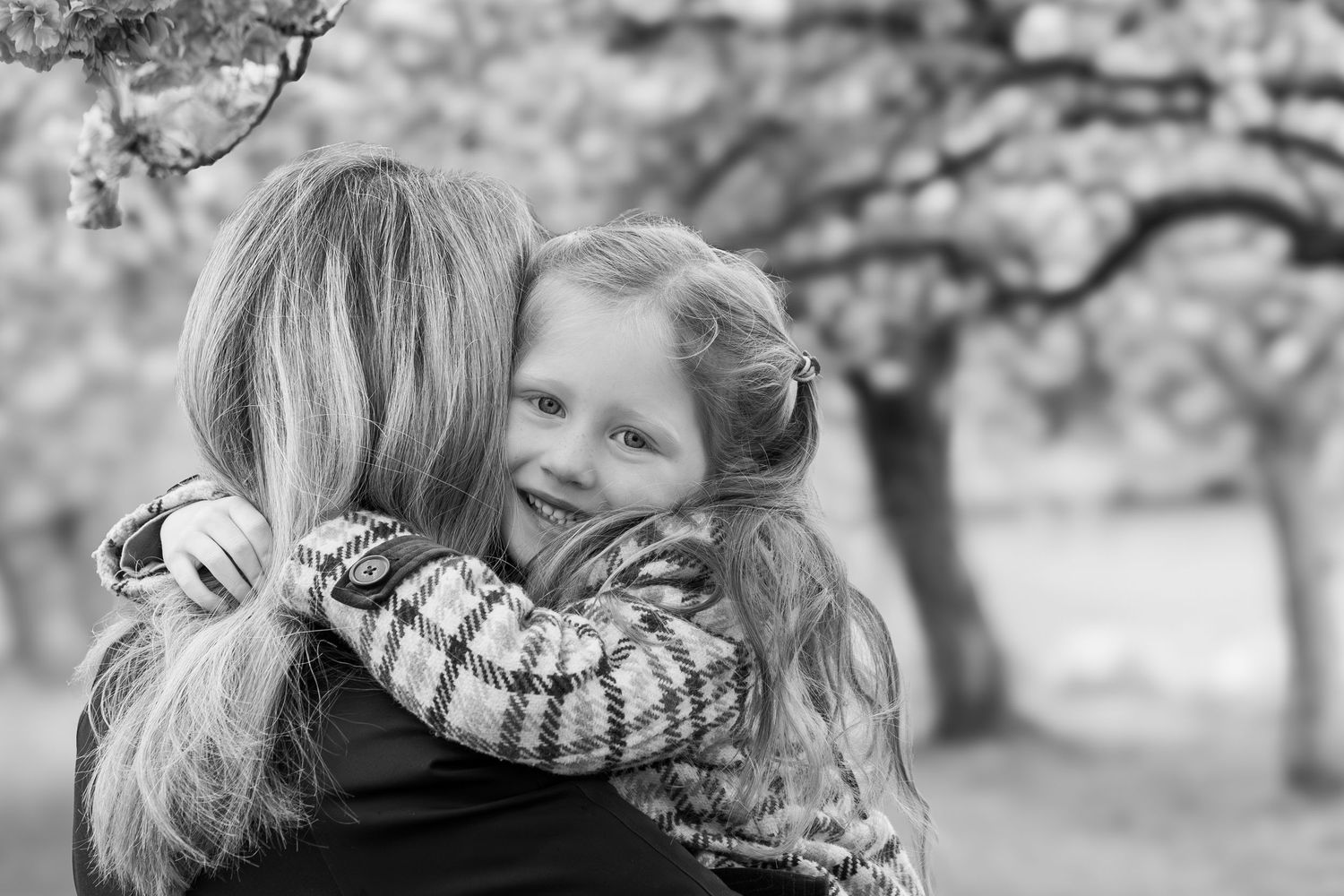 child with arms around mother's neck hugging