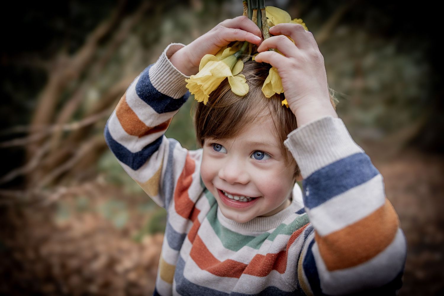 boy holding daffodils on his head