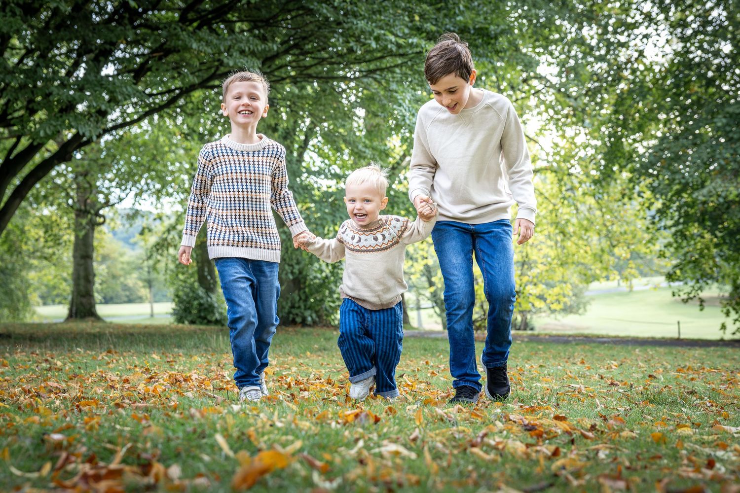 children holding hands and walking in a park
