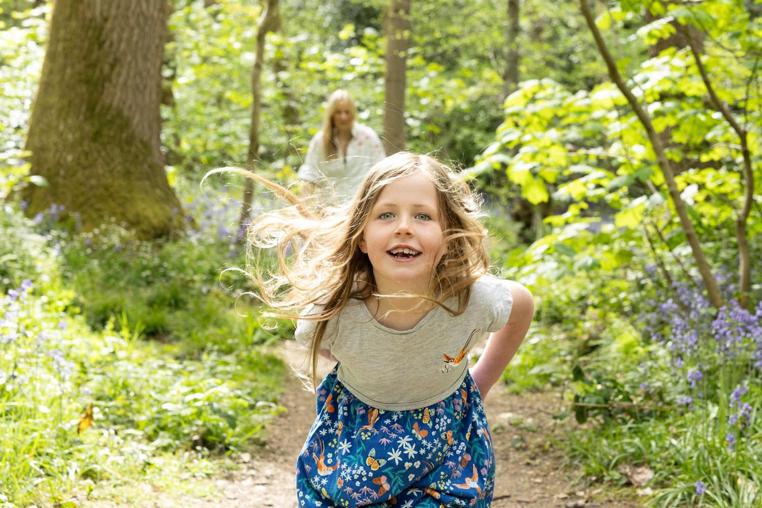 child standing in a bluebell wood