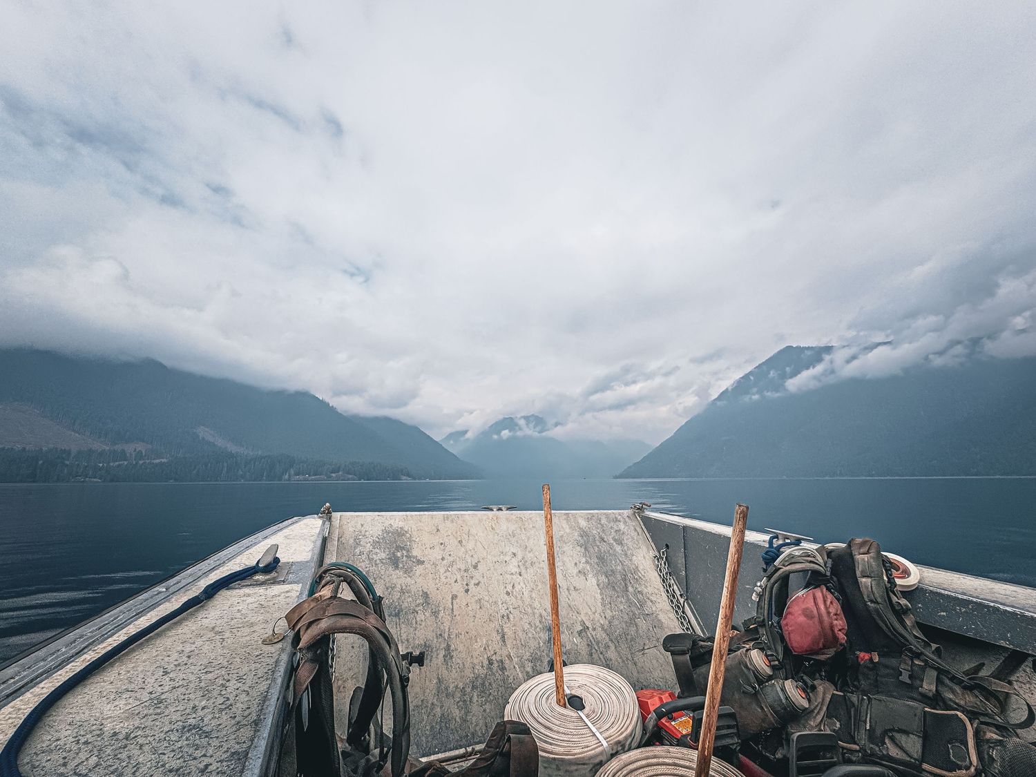 Boat deck with equipment against a backdrop of misty mountains and lake.