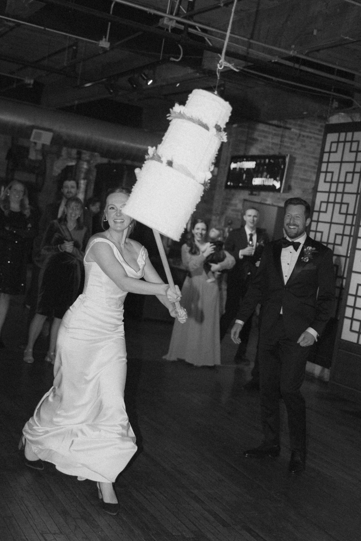 Black and white sequence of a wedding couple's first dance with a dramatic dip on a wooden dance floor.