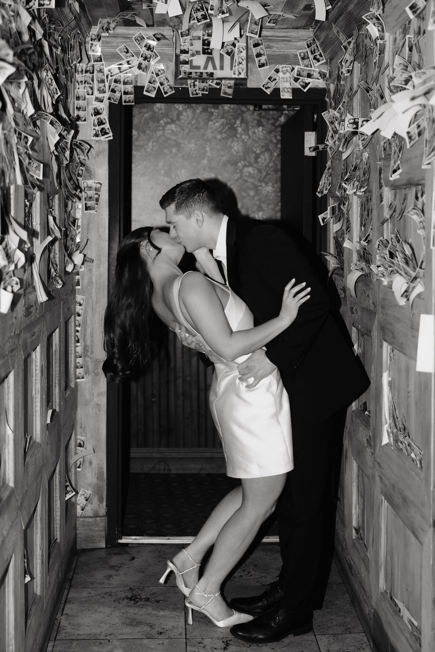 A series of black and white photos showing someone reaching up to interact with papers posted on a wall.