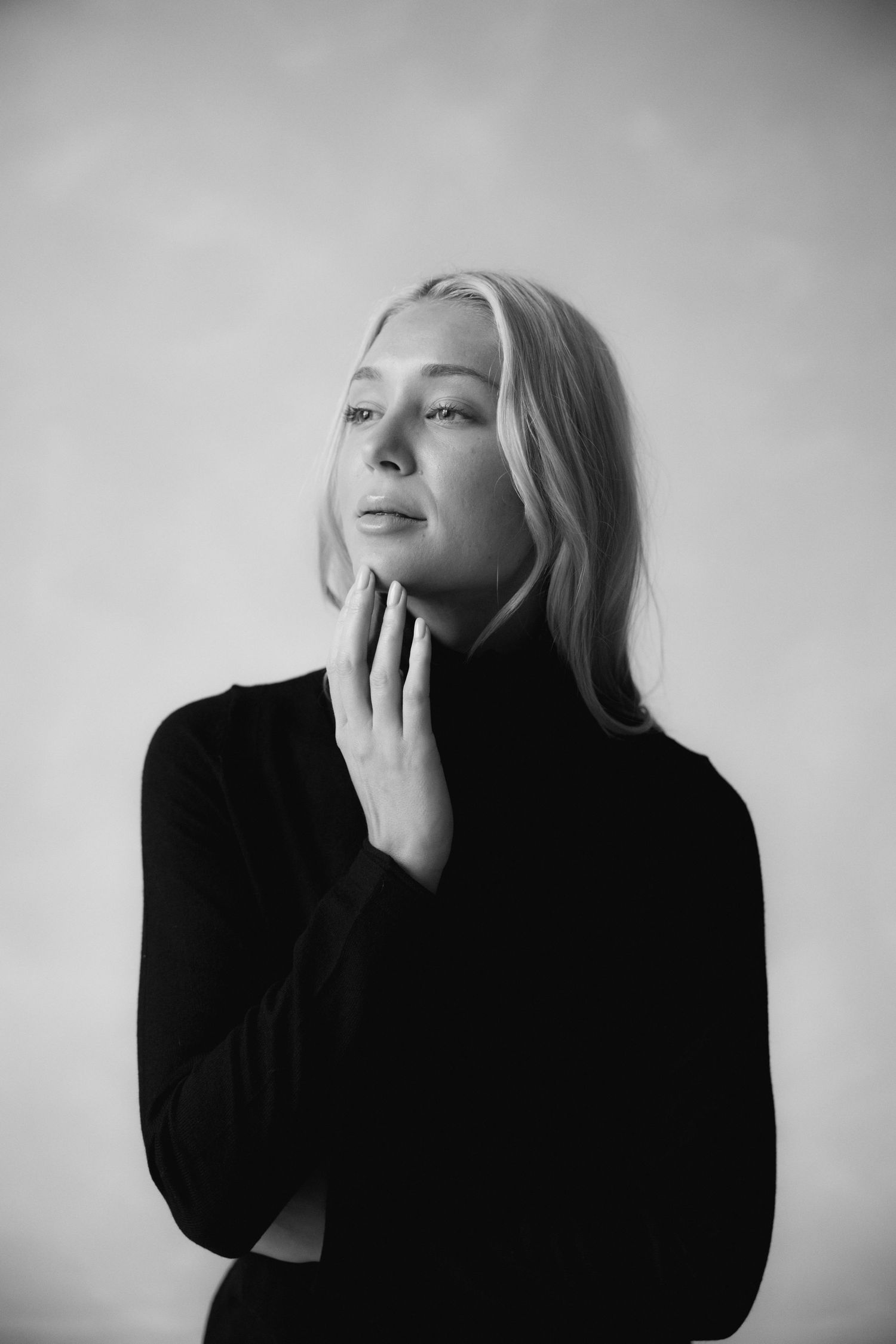 High contrast black and white portrait series showing contemplative poses in studio setting.
