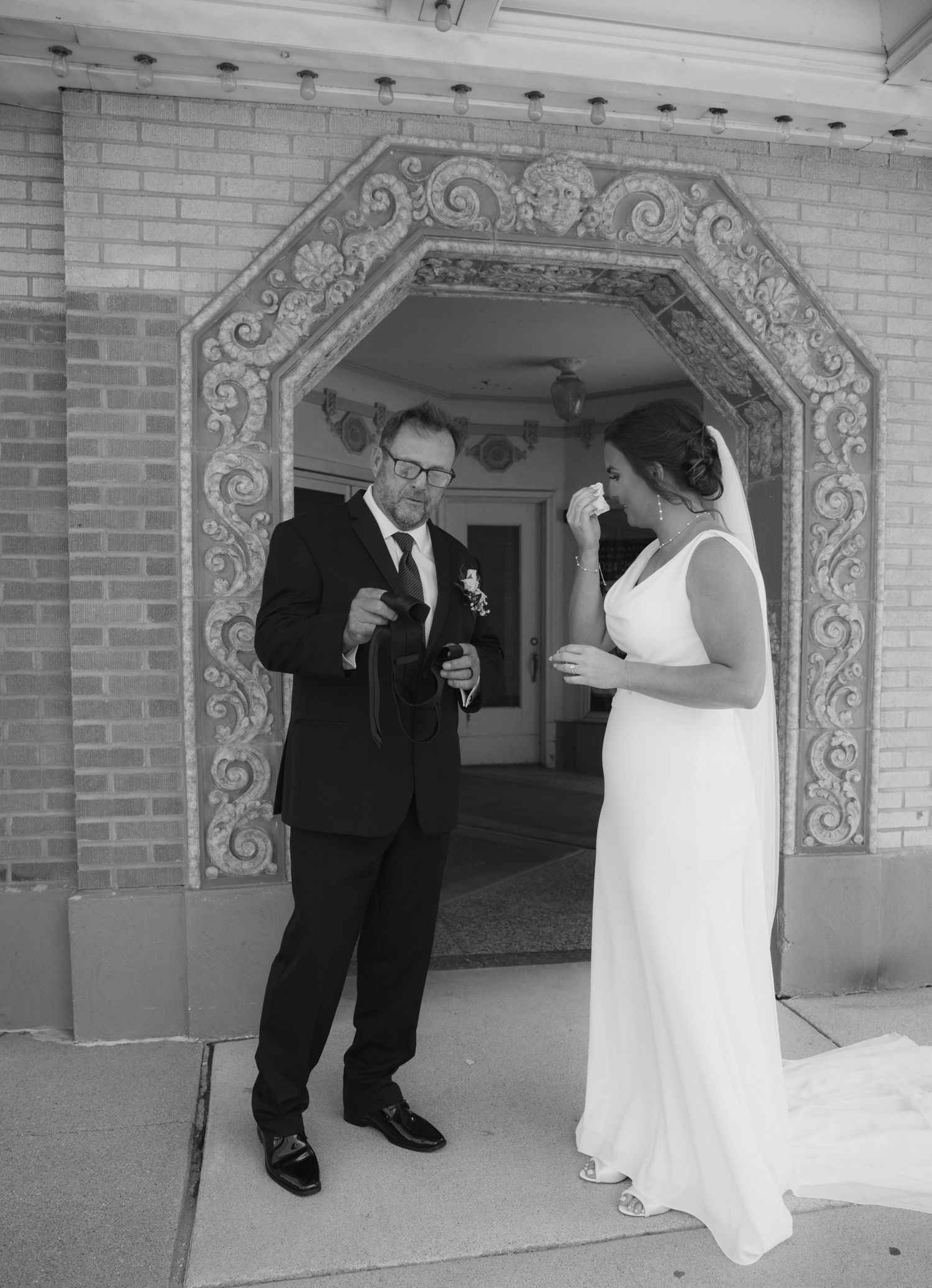 A series of black and white photos showing a first look sequence between a couple before their wedding ceremony.