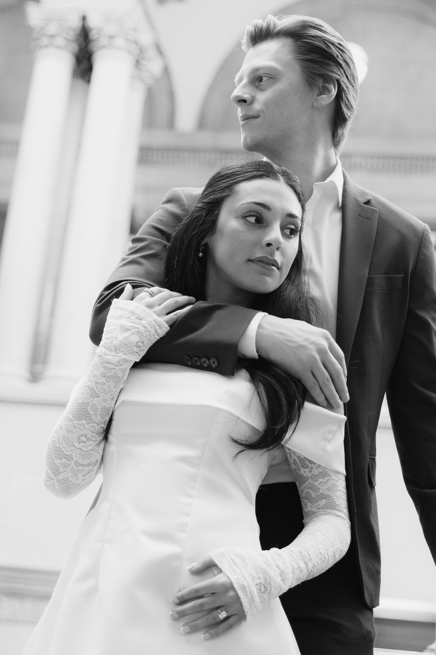 A black and white photo series showing a couple in wedding attire embracing in romantic poses against a light backdrop.