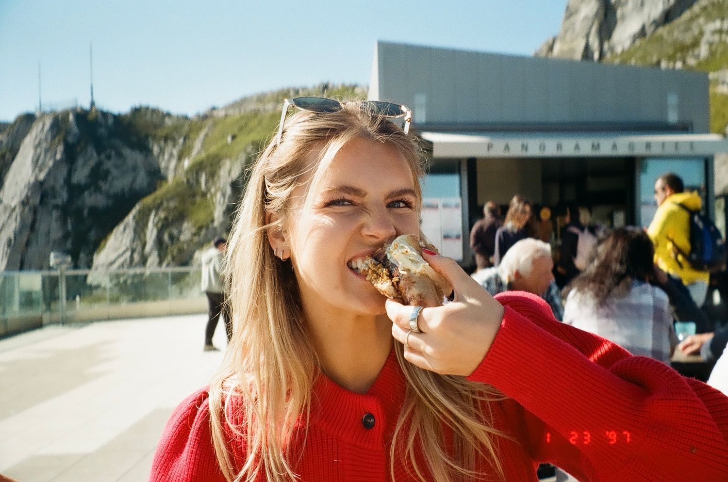 People enjoying drinks and scenic coastal views from an outdoor patio overlooking rugged cliffs and ocean waves.