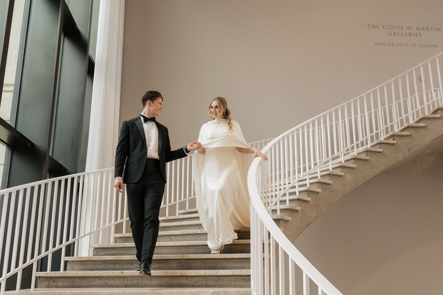 A wedding couple descends an elegant white spiral staircase in a series of romantic photographs.