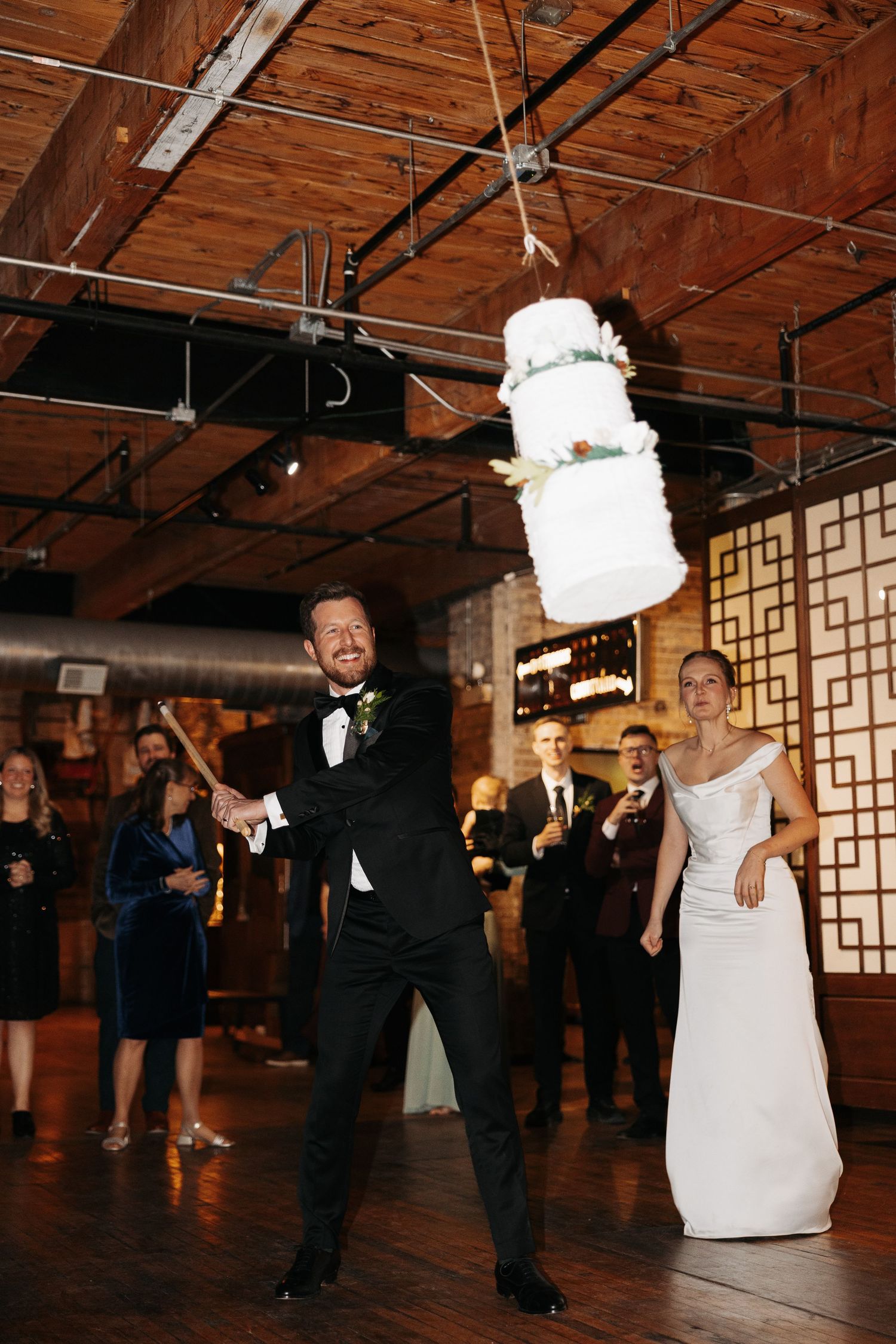 A sequence of wedding dance photos showing a couple performing a fun spin move on a rustic wooden dance floor.