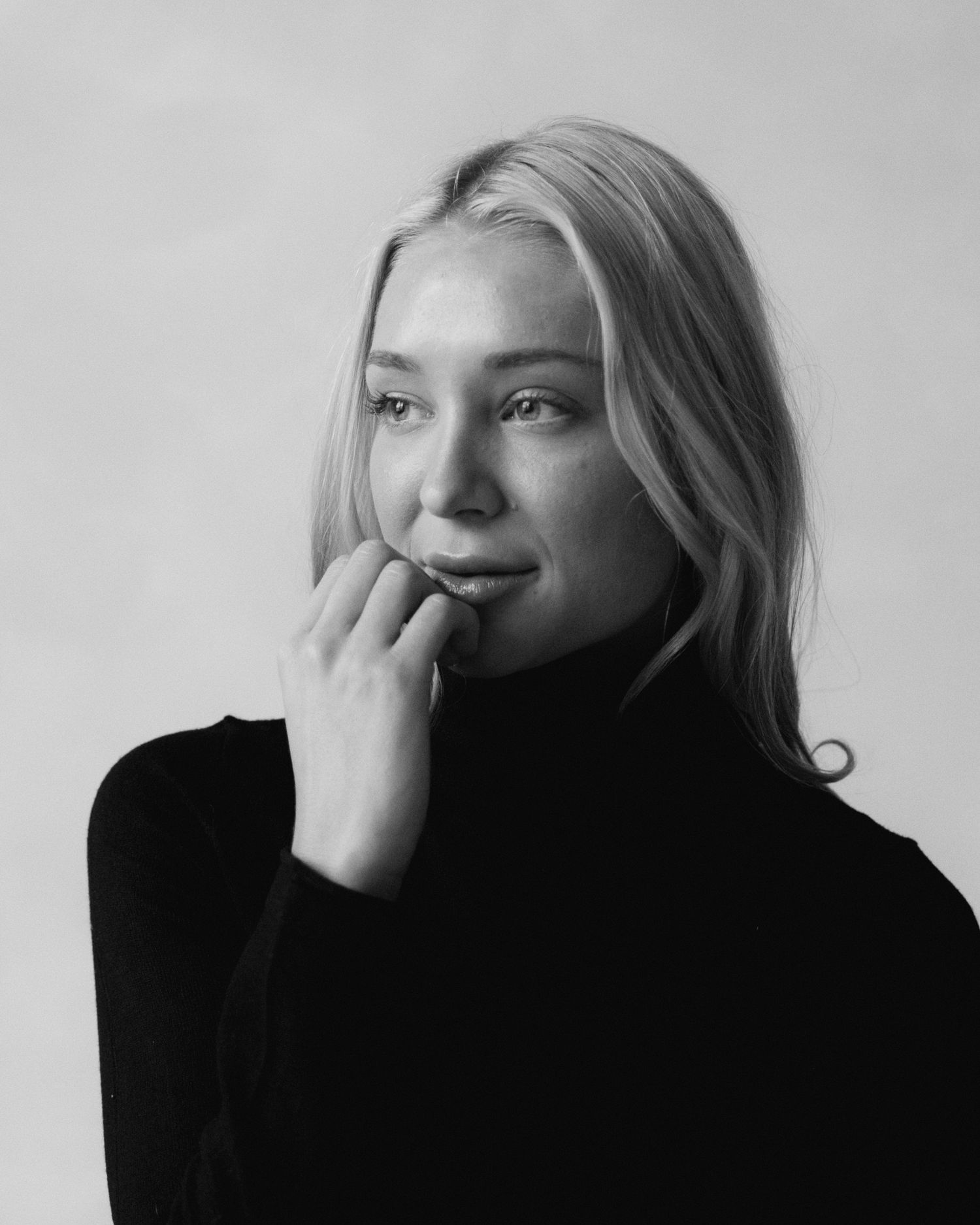 A series of black and white portraits showing a person in dark clothing against a light background.