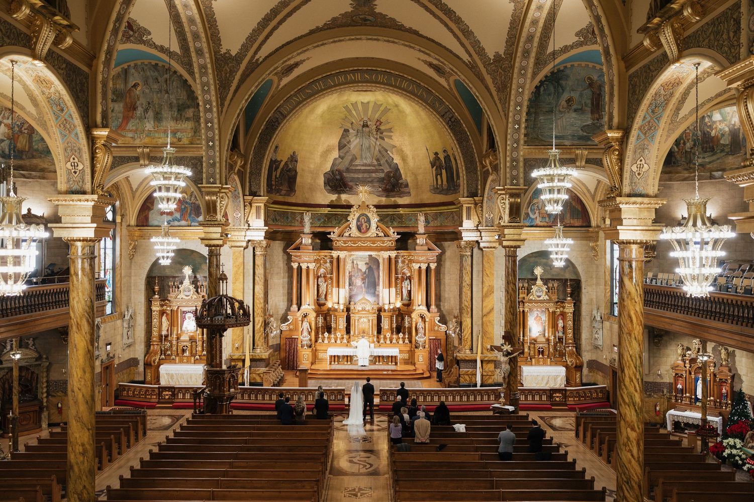 Panoramic view of an ornate church interior with vaulted ceilings and gilded details.