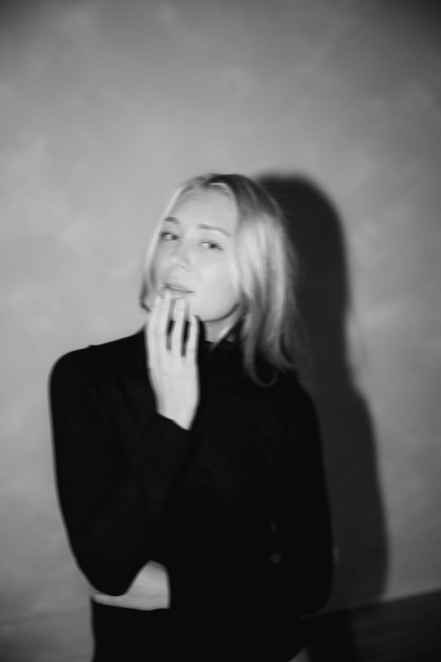 Dramatic black and white series showing emotional poses with hands covering face against dark background.