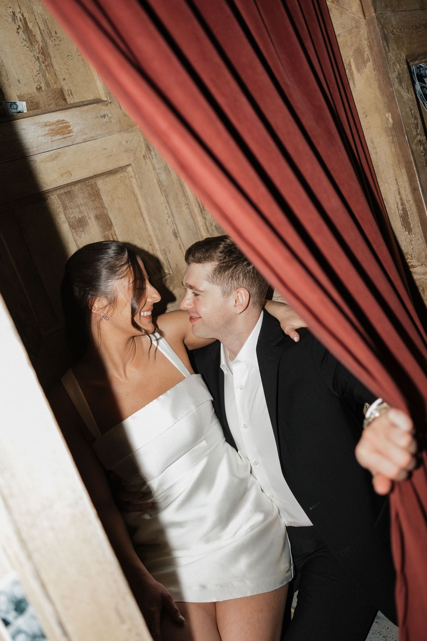 Romantic photo sequence with a red curtain and wooden beams creating a moody atmosphere.