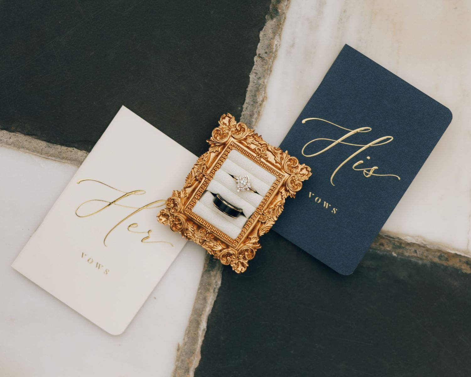 Navy blue and white wedding stationery with gold decorative frames.
