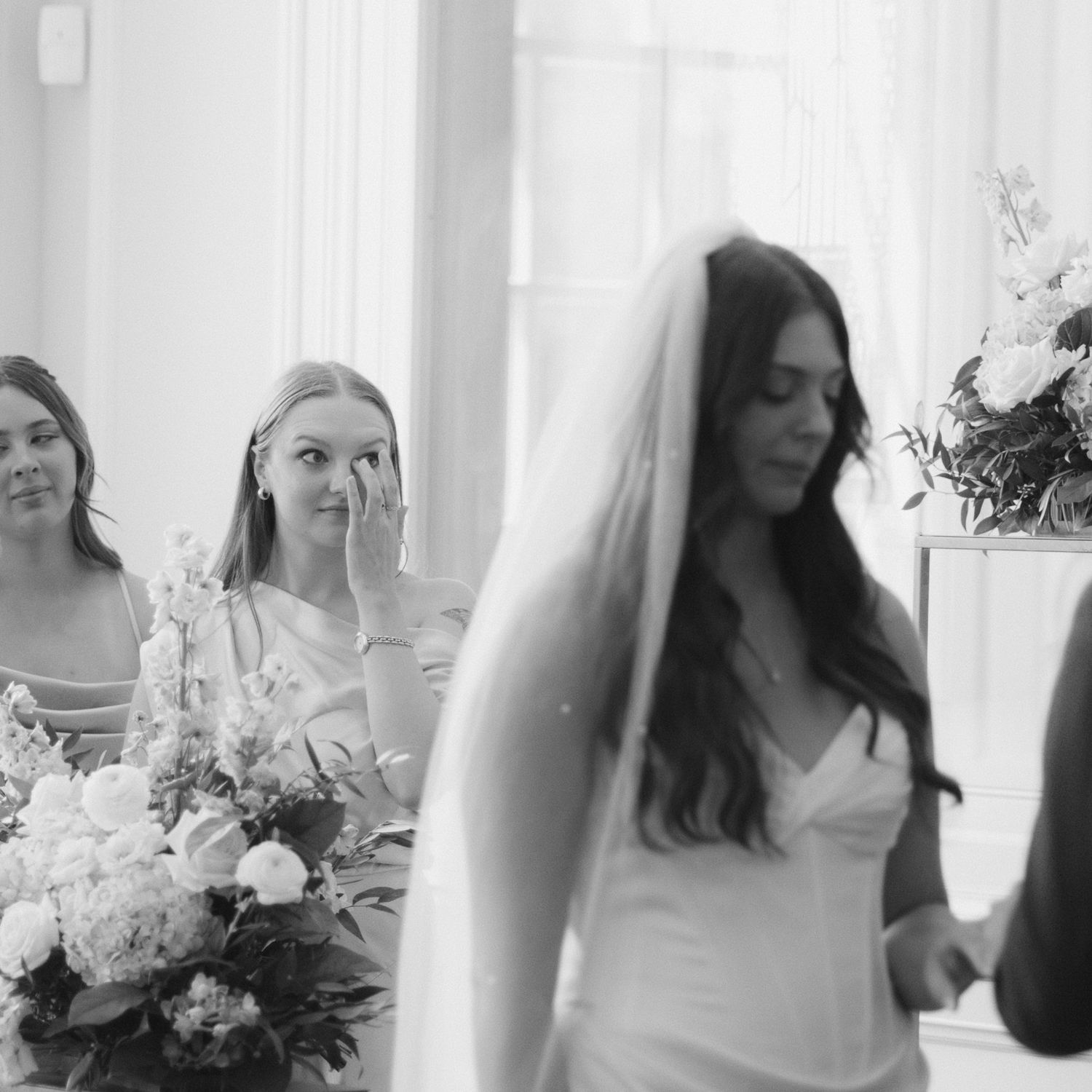 A series of black and white wedding photos showing candid moments and floral arrangements.