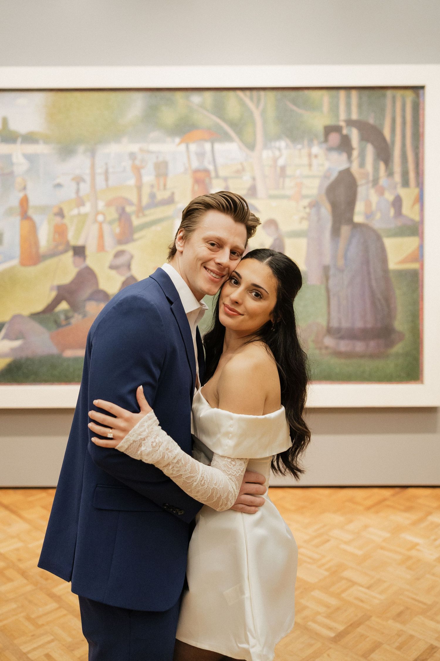 A romantic photoshoot in an art gallery with a couple posing in front of impressionist paintings.