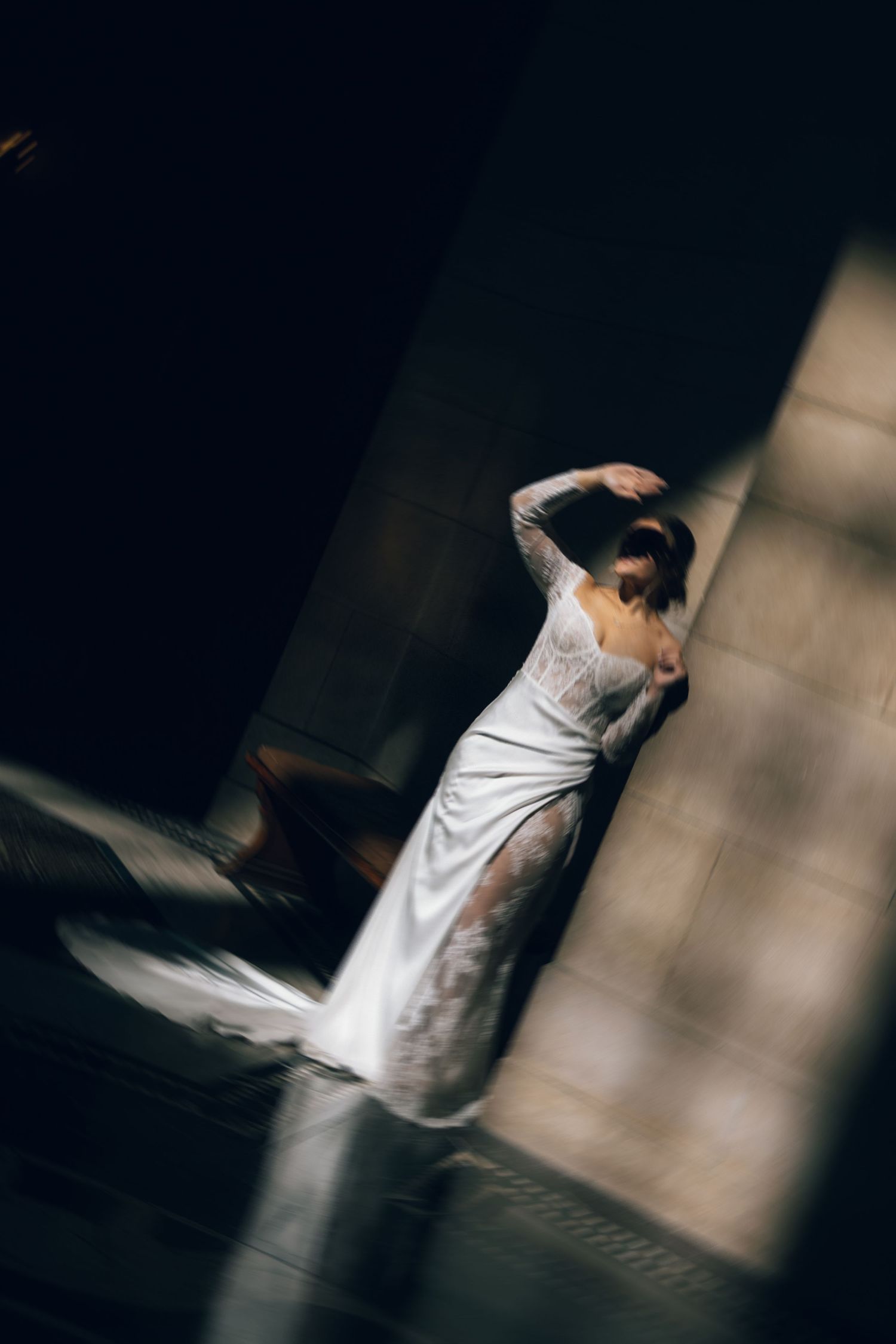 Artistic silhouette photo of a person in a wedding dress against dramatic lighting.