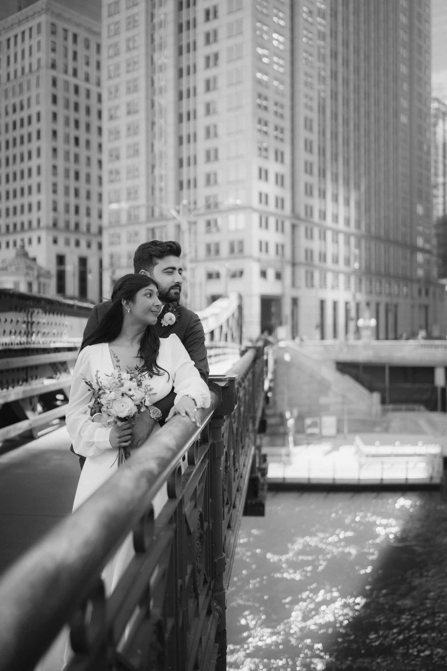 A series of romantic black and white photos showing a couple embracing by a river in an urban setting.